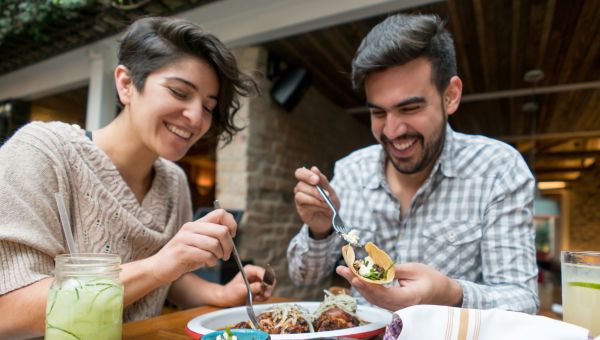 a happy couple enjoys dinner at an open-air Mexican restaurant