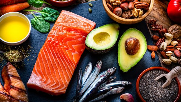 Healthy foods, including salmon, avocado, and nuts, that are good for someone who is breastfeeding.