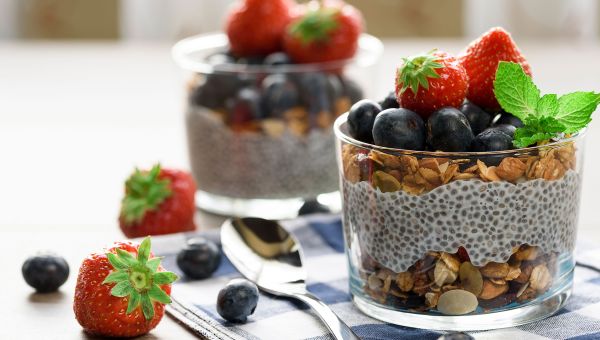A chia pudding parfait under 400 calories surrounded by nutritious berries.