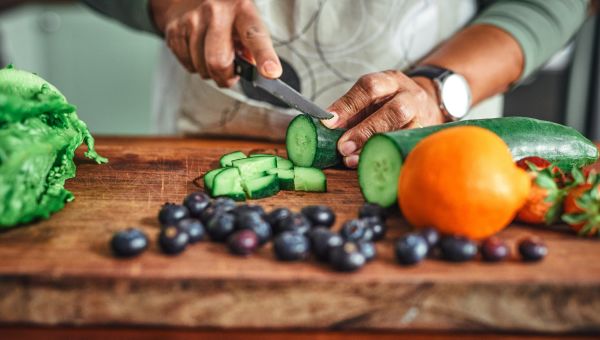 man chopping vegetables on wooden surface