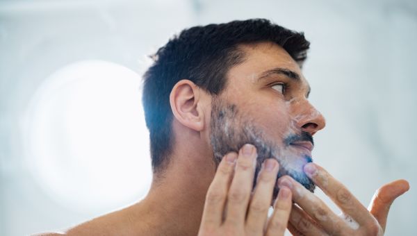 man with beard washing face