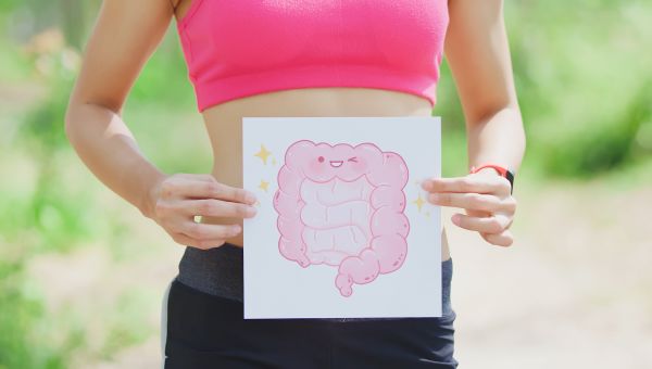 Woman holding an illustration of a healthy gut up to her bare abdomen