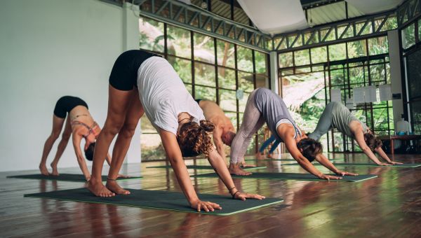 gym class doing downward dog yoga pose