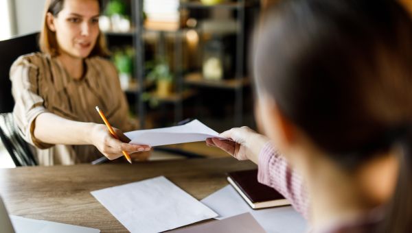 Business woman accepting extra work from a colleague