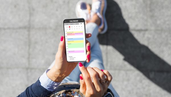 young woman updating calendar on phone