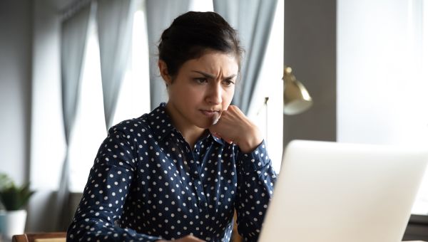 concerned woman looking at her laptop