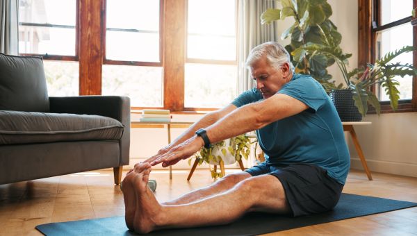 man stretching at home on mat