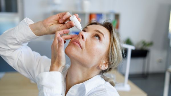 woman putting in eye drops