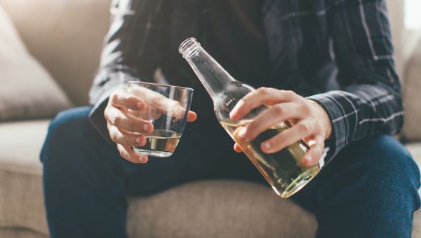 man pouring a bottle of beer into a glass