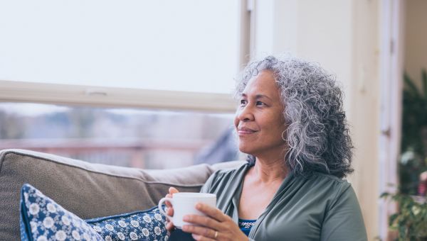 mature woman relaxing on couch with cup of tea