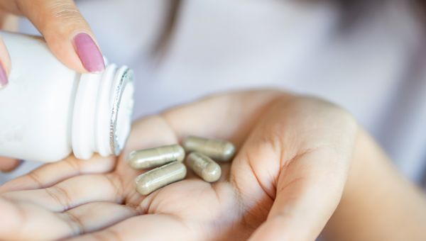 woman pouring reformulated AREDS 2 supplement tablets out into her hand
