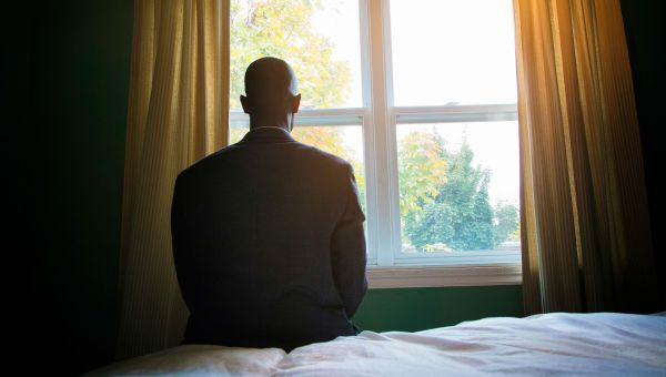 a victim of sexual assault staring out of a window in a dark room