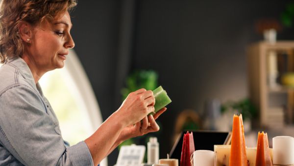 A woman fine detailing a handmade candle