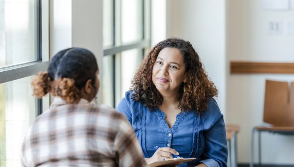 Young adult Black female speaking to counselor