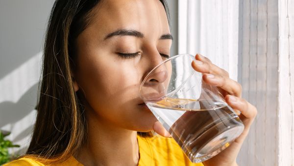 closeup view of a young woman drinking a glass of water