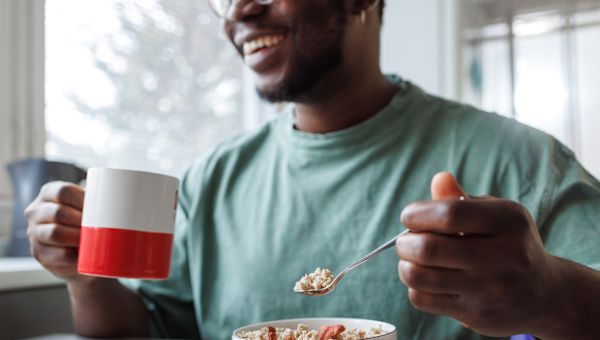 man eating bowl of oatmeal at home