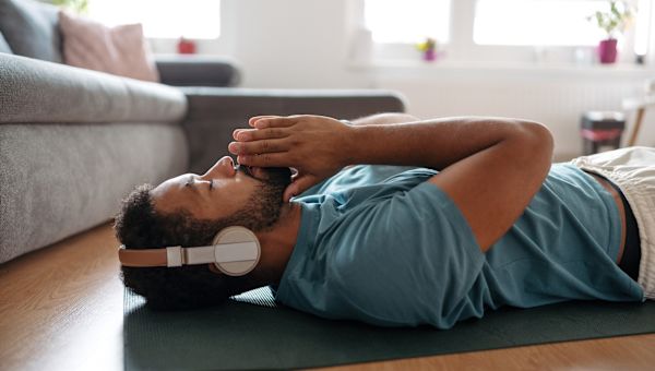 man wearing headphones deep breathing at home