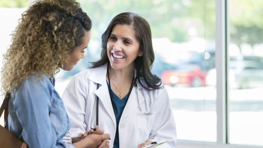 Doctor talking and smiling with female patient.