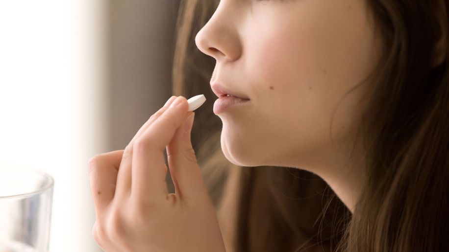 Woman taking non-nicotine quitting aid.