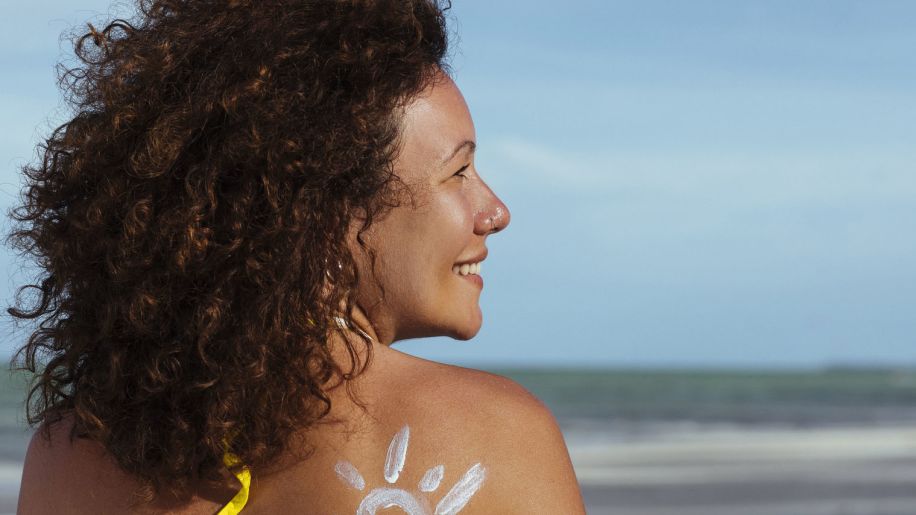 mature woman at beach with sunscreen