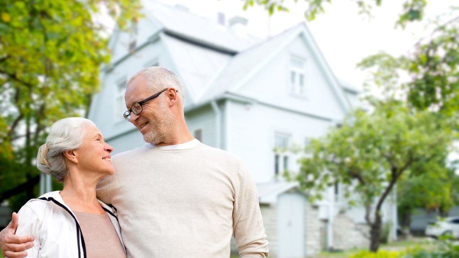 senior couple outside home, house