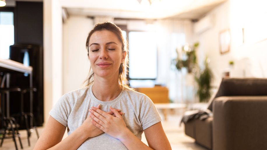 woman eyes closed hands over heart