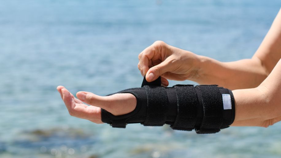 woman strapping orthopedic brace on arm