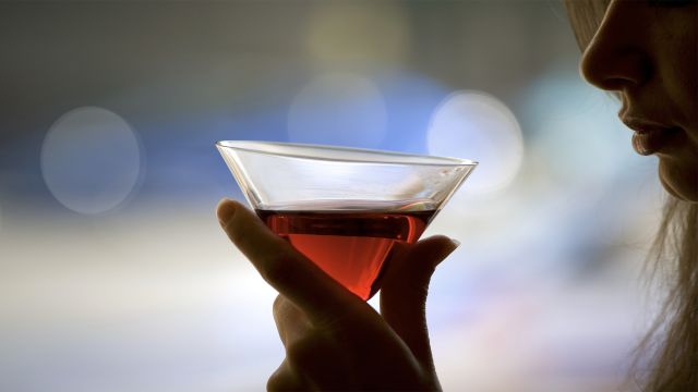 A woman drinking alcohol from a martini glass.