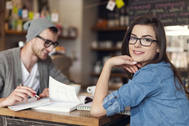 two people at coffee shop, both wearing glasses