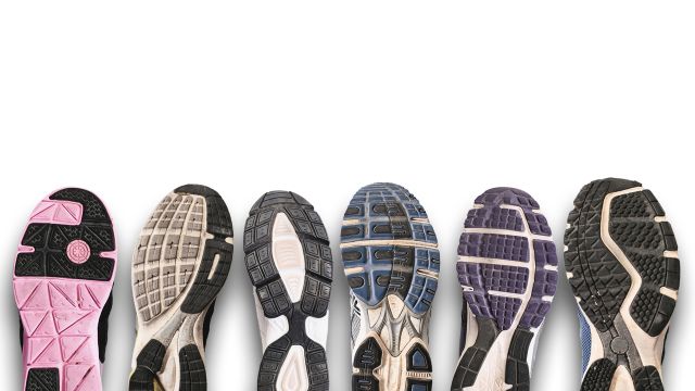 Different shoe soles on a grey background.