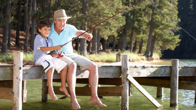 senior man fishing with grandson