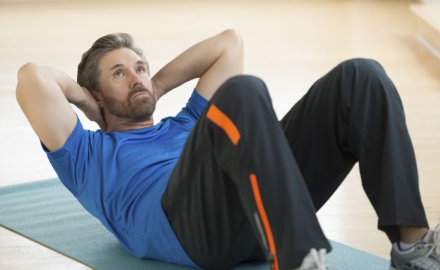 Man Doing Sit-Ups On Exercise Mat