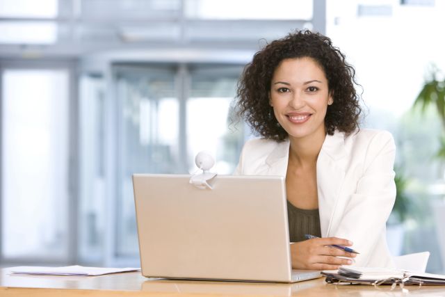 young pretty woman staring at camera smiling, businesswoman, laptop