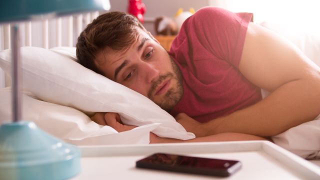 Man In Bed Woken By Alarm On Mobile Phone