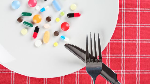 pills, plate, knife, fork, plaid red tablecloth