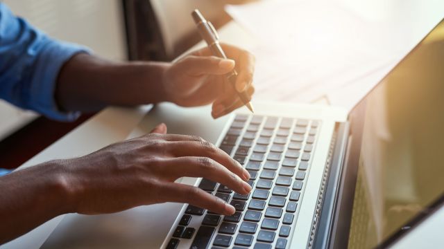 Fingers type on a laptop as someone does research on their multiple myeloma blood cancer diagnosis. 