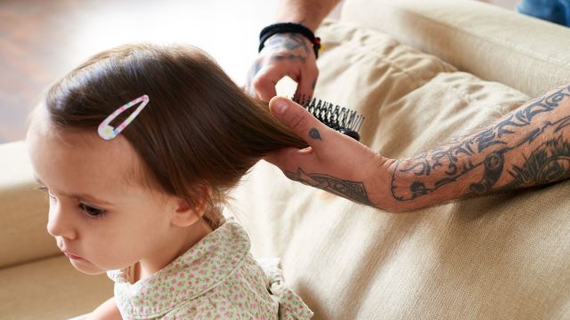 Father combing little girl's hair