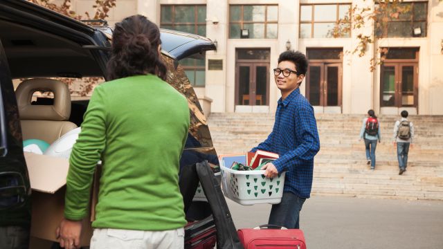 Young man moving into college dormitory