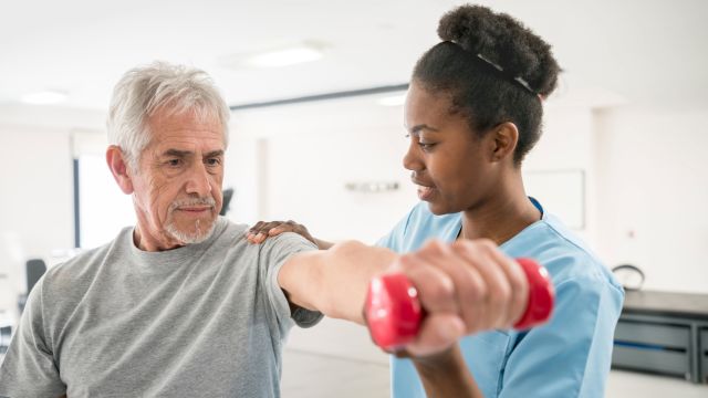 Physical therapist assisting a senior patient