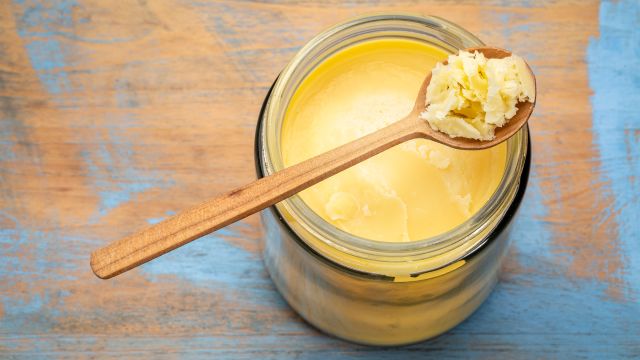 On a surface sits a jar of ghee, which some say is good for health. Learn ghee's health benefits and possible disadvantages. 