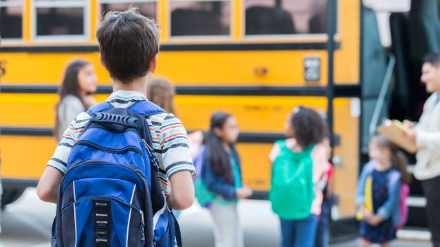 Little boy standing in line for the school bus