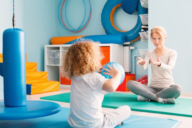 A child with a FAOD works with a physical therapist.