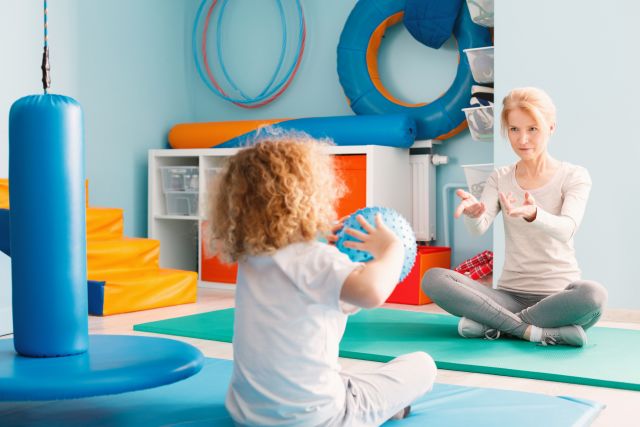 A child with a FAOD works with a physical therapist.