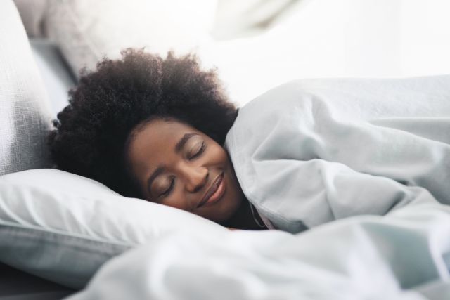 Black woman sleeping cozily in her bed