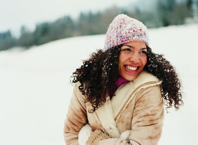 Woman in winter clothes looking happy outside in show