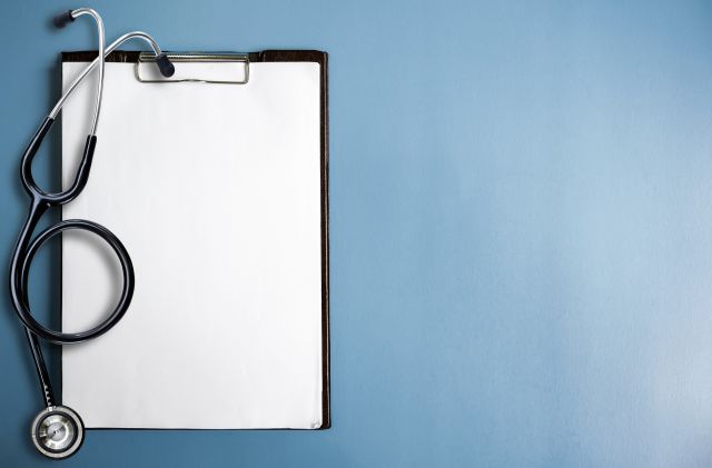 A stethoscope and clipboard on a blue background. A physical exam and medical history are important when diagnosing TD.
