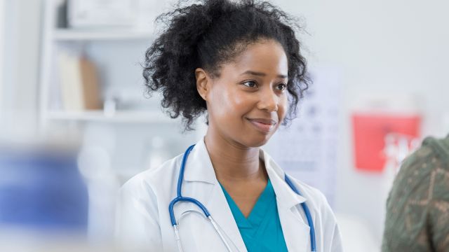 Physician with a clipboard speaks with a patient.