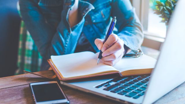 woman writing plan in journal