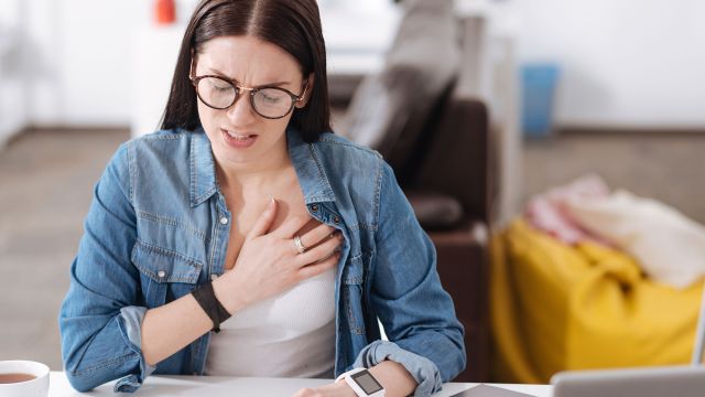 Young woman suffering an asthma attack.