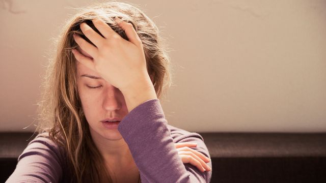 Woman in anguish holding her head.